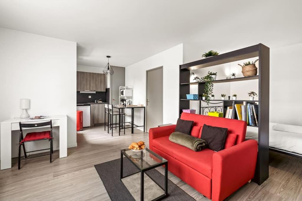 un salon avec un canapé rouge et une cuisine dans l'établissement apartment ideal location for Lyon Center, à Villeurbanne