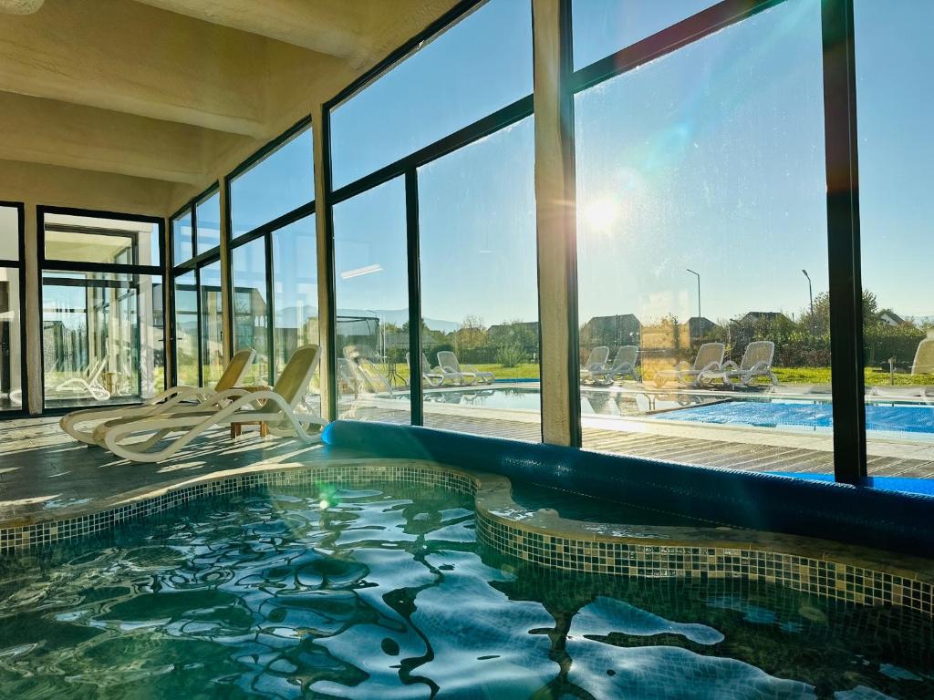 オクナ・シュガタグにあるPensiunea Marea Alpina, Maramuresの大きな窓のある建物内のプール