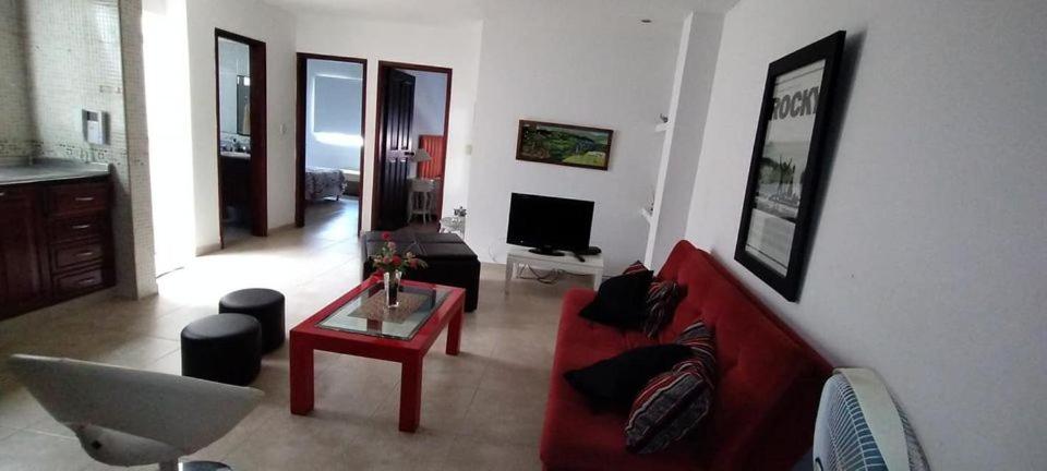 a living room with a red couch and a table at Apartamento Vacacional centro San Gil in San Gil