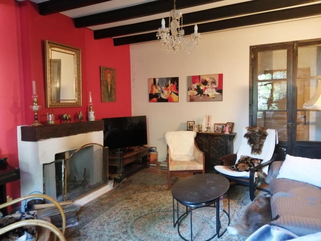 d'un salon avec une cheminée et des murs rouges. dans l'établissement Maison de ville avec jardin, à Saujon