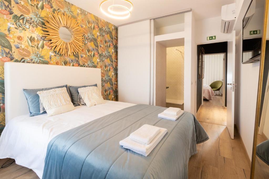 a bedroom with a large bed with towels on it at Barra Apartament Design in Gafanha da Nazaré