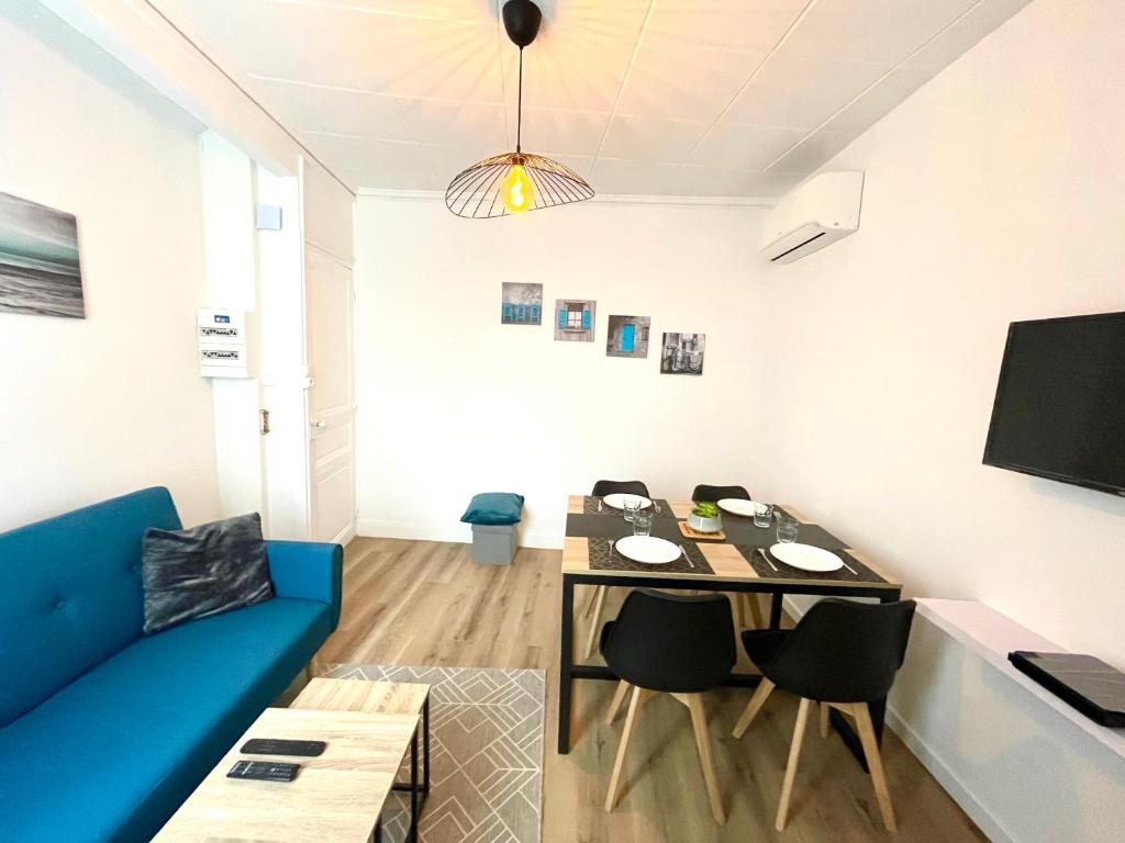 un salon avec un canapé bleu et une table dans l'établissement Le Saintonge, à Saintes