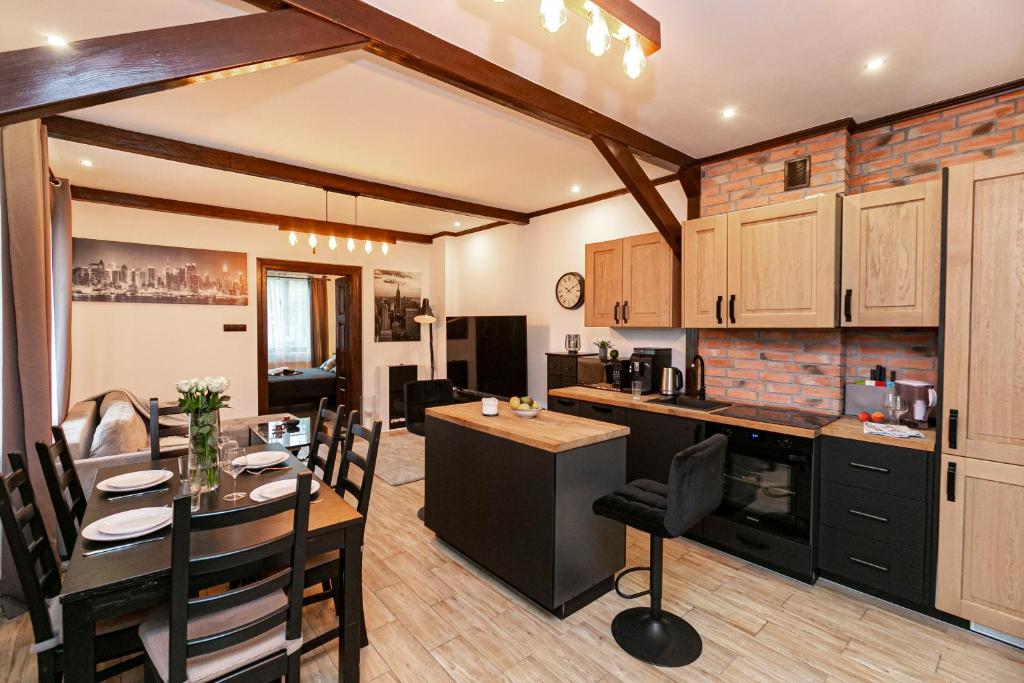 ザモシチにあるBrzozowy Dwór Apartament Iのキッチンとリビングルーム（テーブル付き）とダイニングルーム