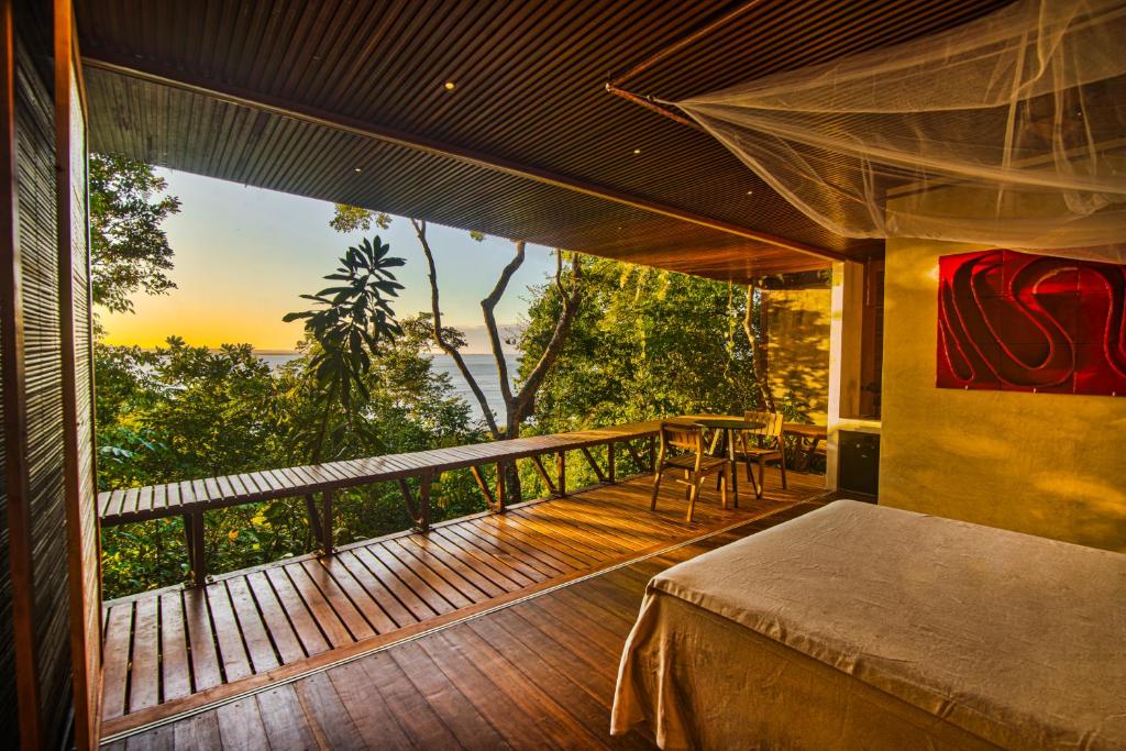 a bedroom with a balcony with a view of the ocean at A Casinha da Floresta in Gamboa