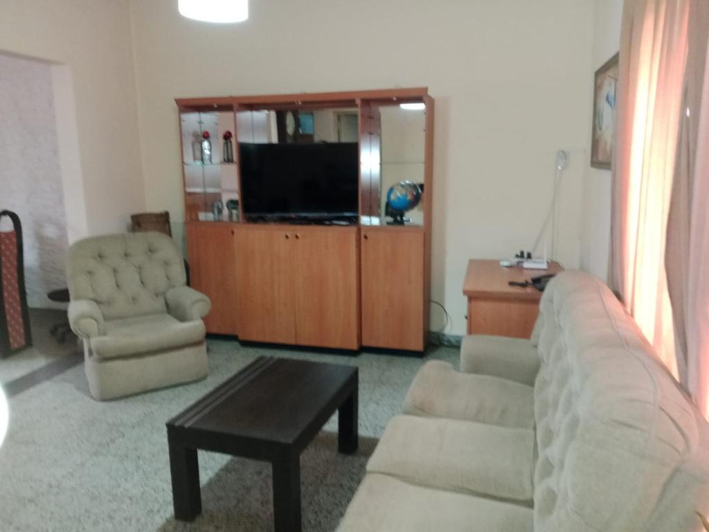 a living room with a couch and a chair and a television at Casa Esquina in Guaymallen