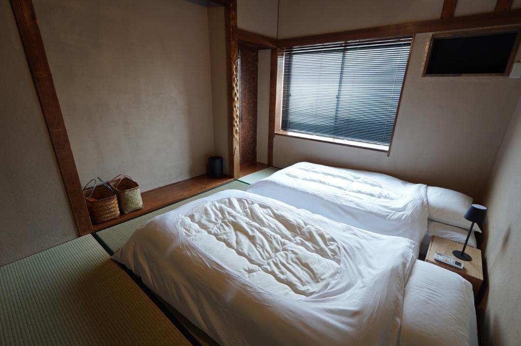 Postel nebo postele na pokoji v ubytování 宿屋GONDO aioi