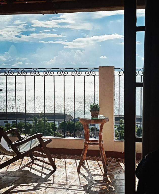 a table and chair on a balcony with a view at Pousada Beija Flor in Salvador