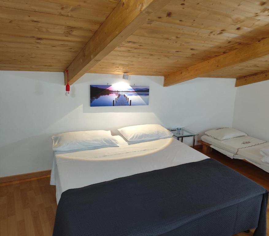 a bedroom with a large white bed and wooden ceilings at BeB Silvia in Santa Maria Capua Vetere