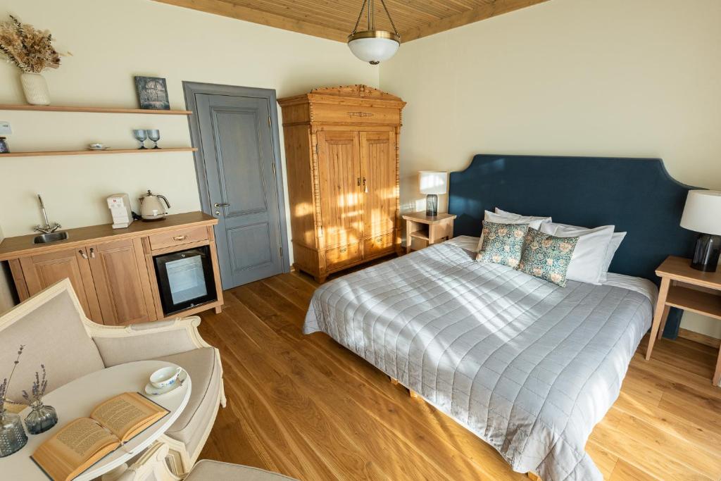 a bedroom with a bed and a couch at Karlamuiza Country Hotel in Kārļi