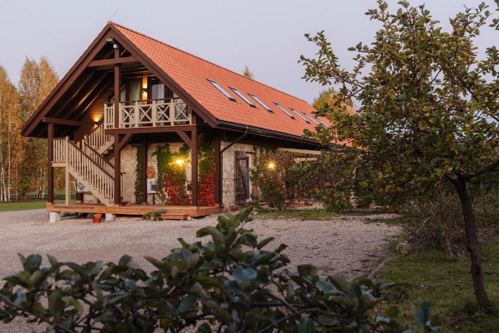 a log cabin with a porch and a deck at Karlamuiza Country Hotel in Kārļi