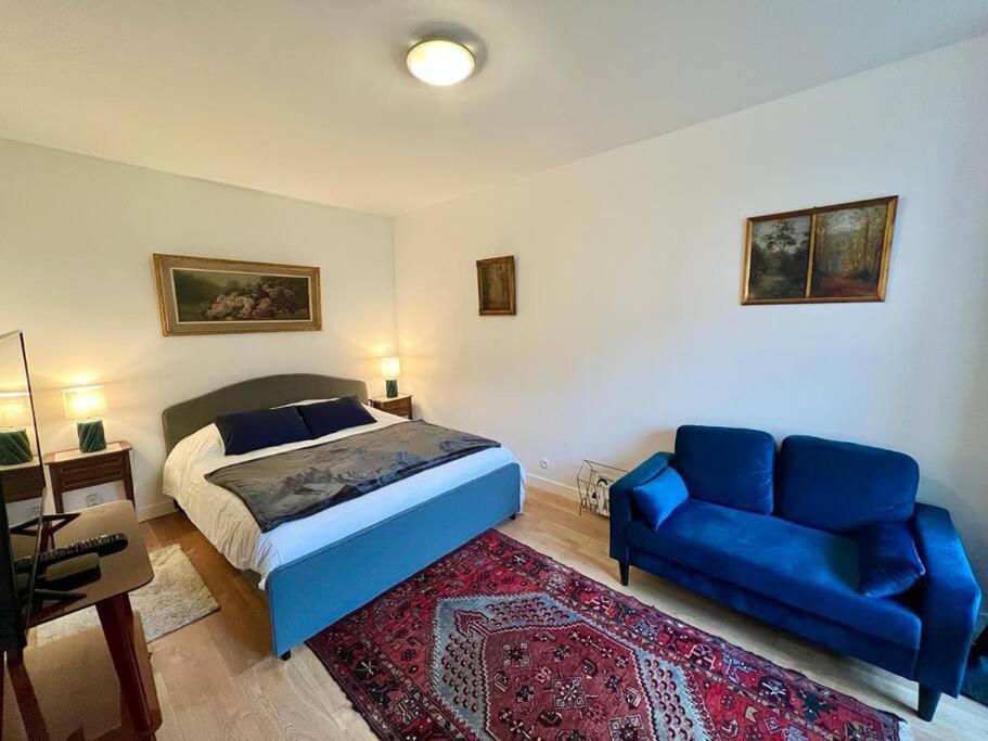- une chambre avec un lit bleu et un canapé bleu dans l'établissement Jardins de Versailles - Le Mythique - 16C, à Versailles