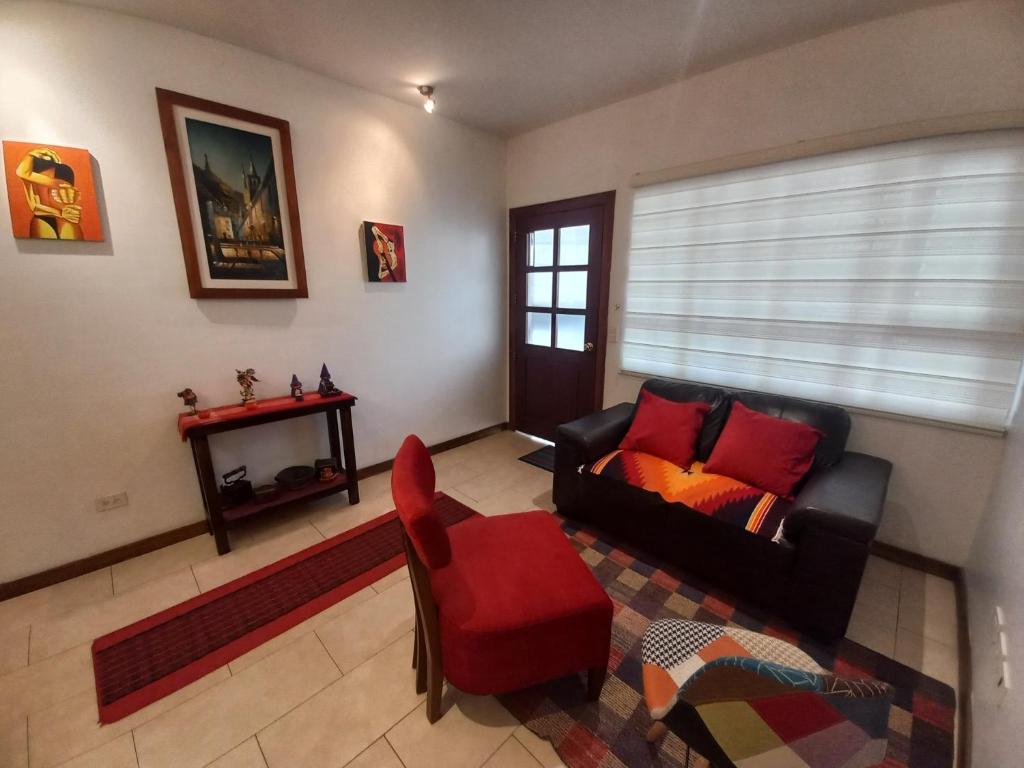 a living room with a couch and a red chair at Apartamento en el CENTRO HISTÓRICO DE QUITO in Quito