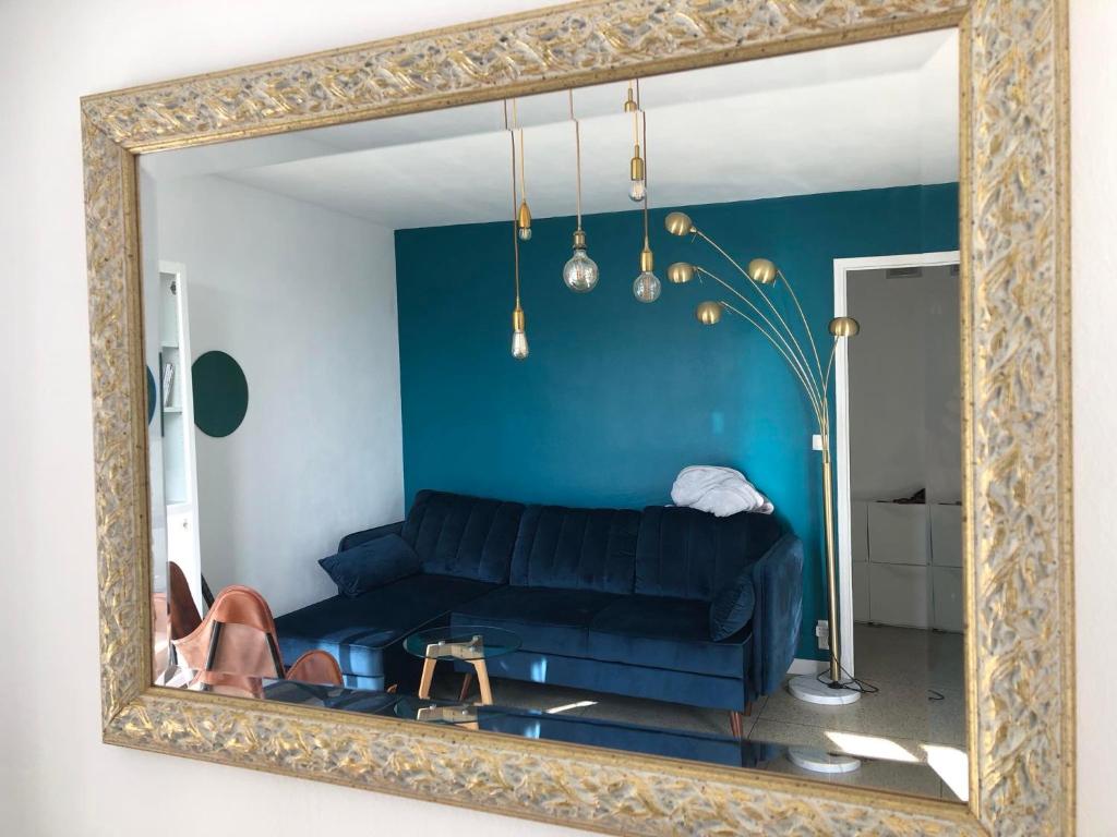 un miroir reflétant un salon avec un canapé dans l'établissement Soleil de mai, à Marseille