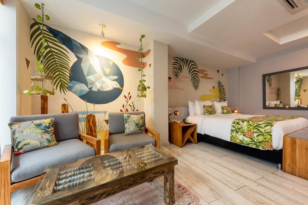a bedroom with a bed and a couch and a table at Townhouse Boutique Hotel in Cartagena de Indias