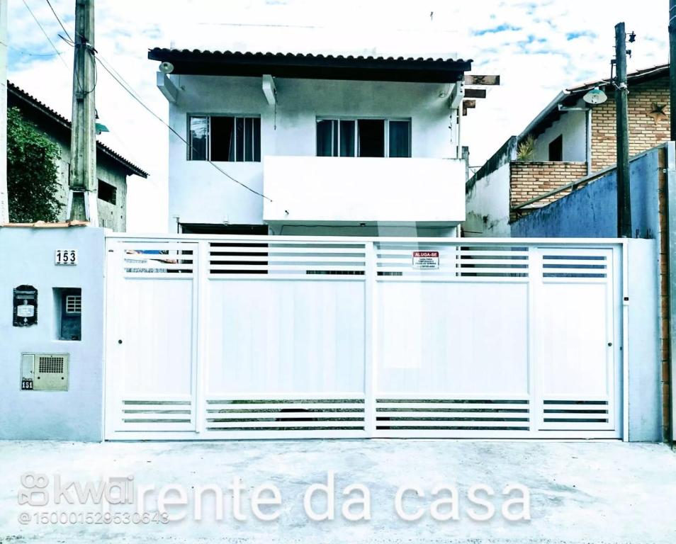 un portail blanc devant une maison blanche dans l'établissement Casa na praia para até 10 pessoas, à São Sebastião
