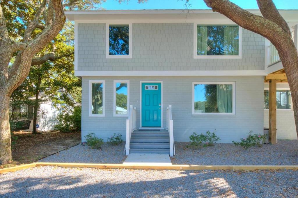 ein weißes Haus mit blauer Tür in der Unterkunft Fishy Fishy Down in Oak Island