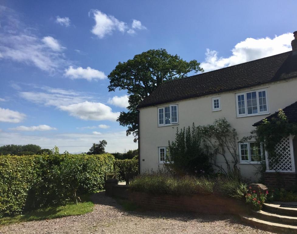a white house with a hedge in front of it at Mulsford Cottage in Malpas