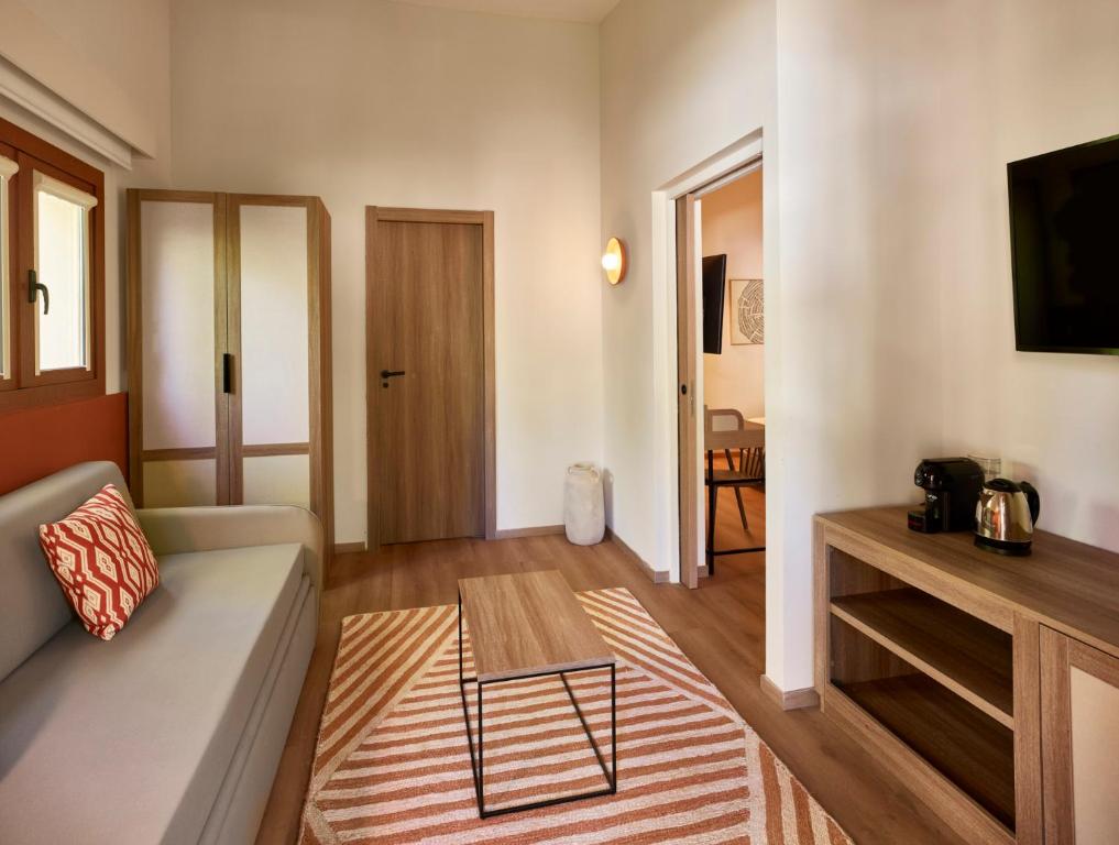 a living room with a couch and a television at Calaserena Resort in Geremèas