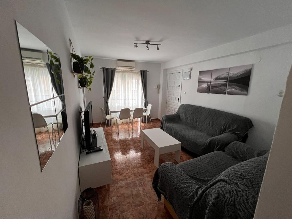 ein Wohnzimmer mit Sofa und Tisch in der Unterkunft Apartamento en el centro de Nerja in Nerja