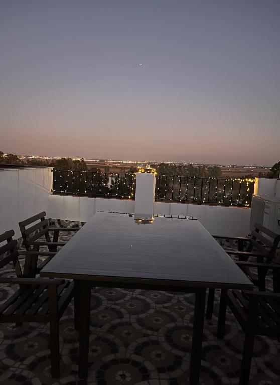 a table on the roof of a building with chairs at ESTUDIO LAS PALMILLAS in Puebla del Río