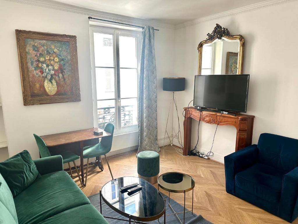 un salon avec un canapé, une table et une télévision dans l'établissement Home Sweet Home Champs de Mars, à Paris