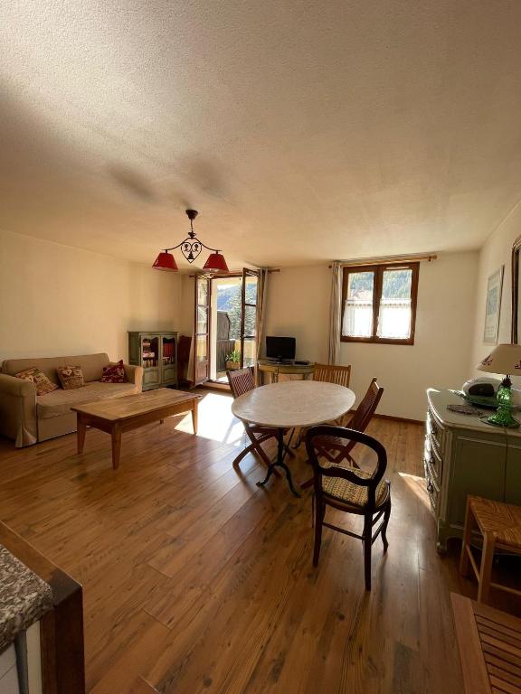 un salon avec une table et un canapé dans l'établissement Appartement 70 m2 au coeur du village d'Allos 2 chambres 5 couchages, à Allos