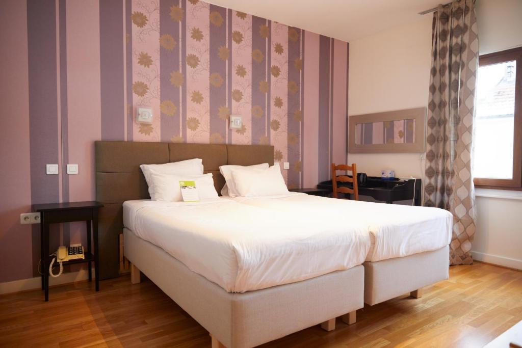 Postel nebo postele na pokoji v ubytování Hotel Le Divona "au coeur de Divonne"