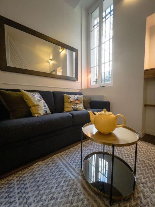 - un salon avec un canapé et une théière sur une table dans l'établissement Île Saint Louis-studio, à Paris