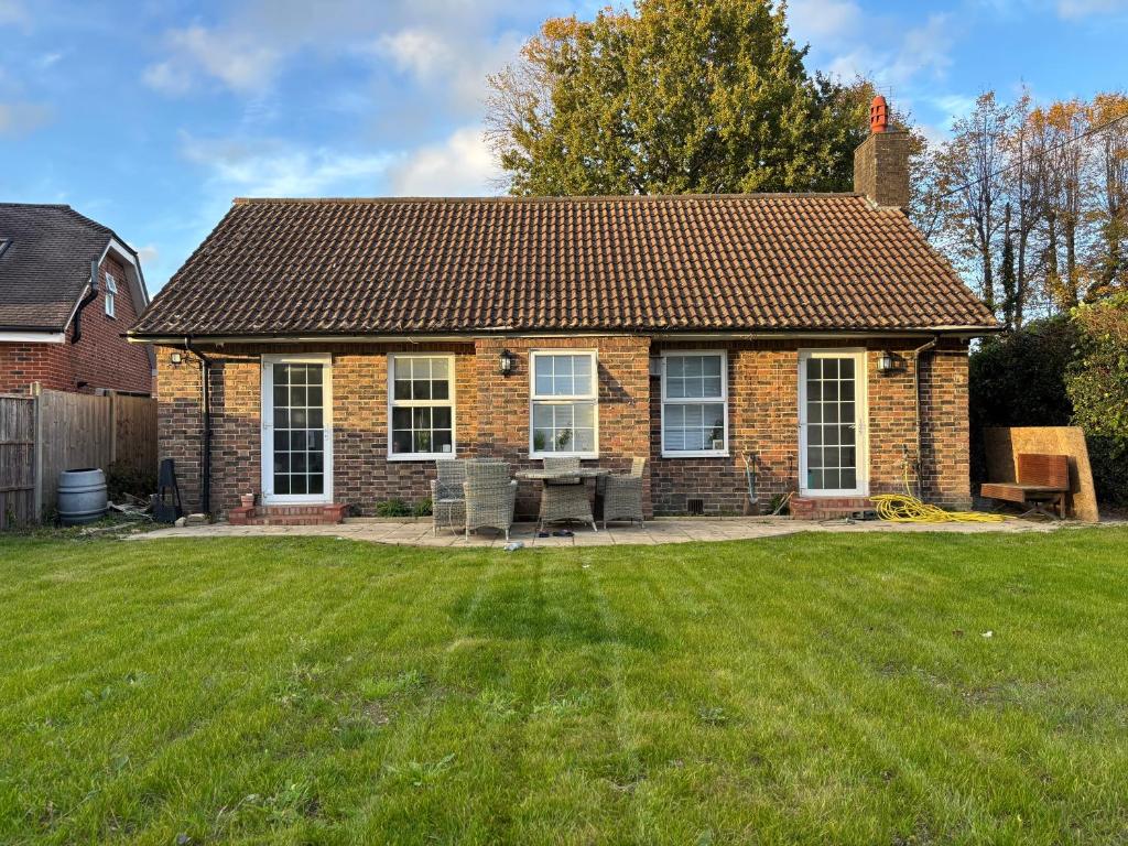 a brick house with a lawn in front of it at Charming 2BR Cottage - Fully Furnished - 10min LGW - Free Parking in Crawley