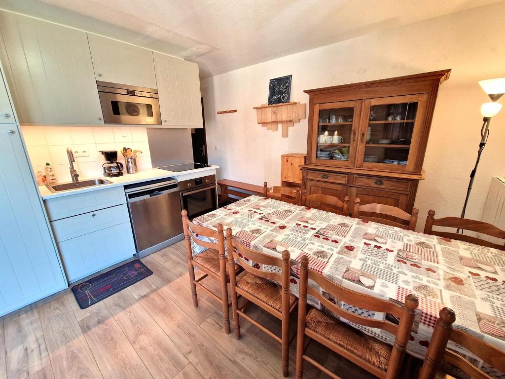 une cuisine avec une table et une cuisine avec une table et des chaises dans l'établissement Bel appartement 3 chambres, 2 salles de bain à Valfréjus, 6/8 personnes - FR-1-265-170, à Valfréjus