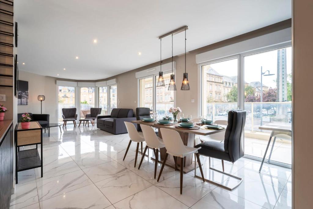 une salle à manger et un salon avec une table et des chaises dans l'établissement Le Vigneulles, à Metz