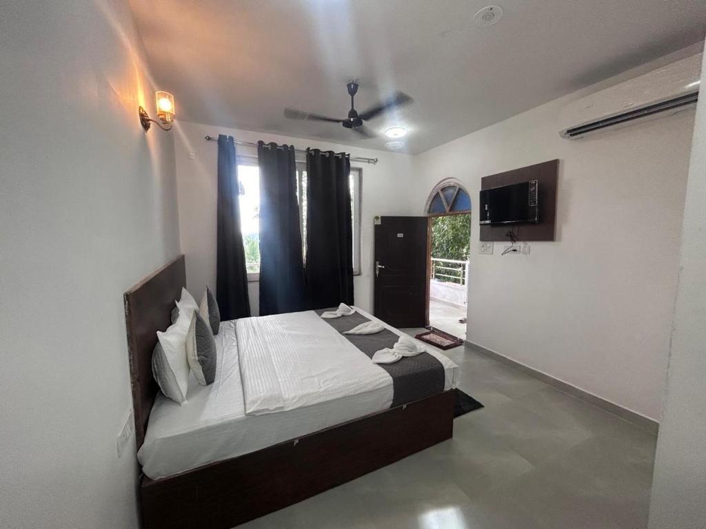 a bedroom with a bed and a tv in it at Hotel blue ocean studio rooms with kitchen baga beach in Calangute