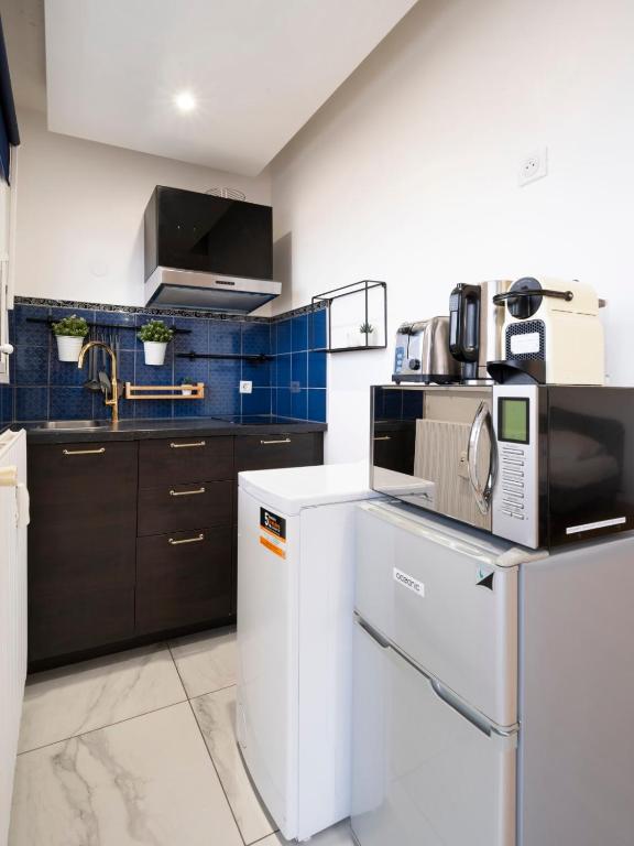 une cuisine avec une cuisinière et un micro-ondes dans l'établissement Le Coislin, à Metz