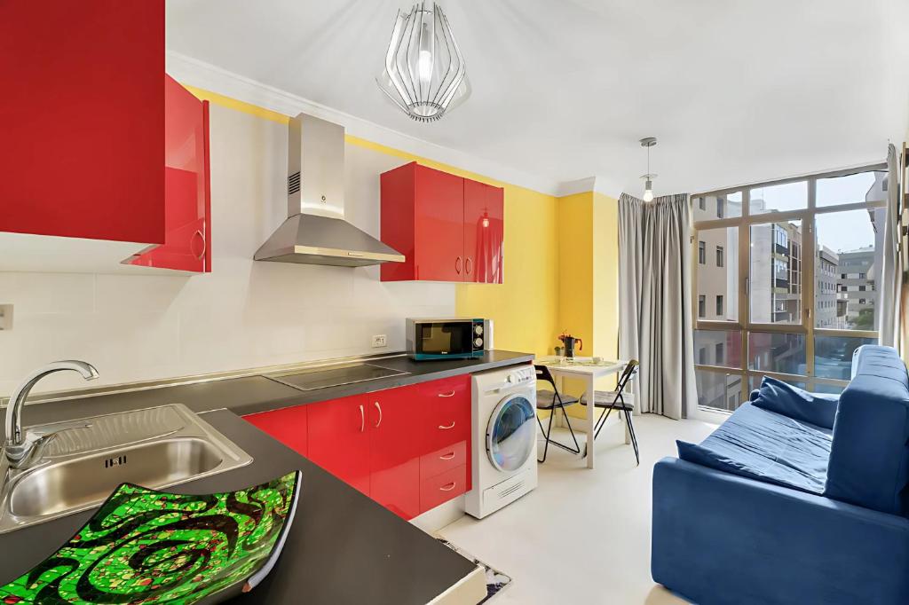 eine Küche mit roten Schränken, einer Spüle und einem Geschirrspüler in der Unterkunft Apartamento en Calle Heraclio Sánchez in La Laguna