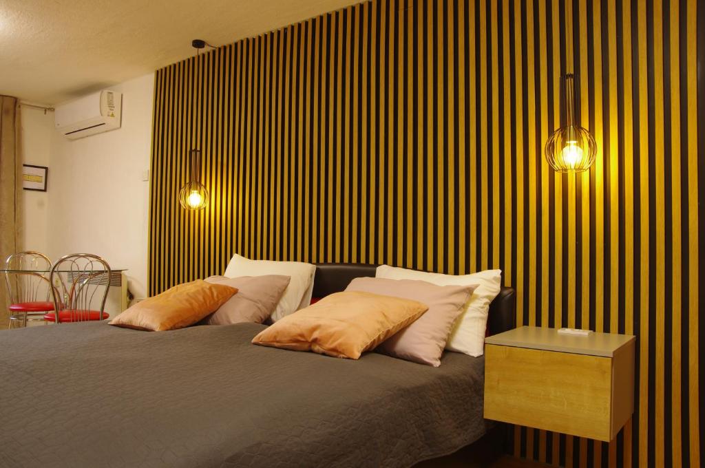 a bedroom with a bed with pillows and a table at Studio apartment Lovrekovic in Zagreb