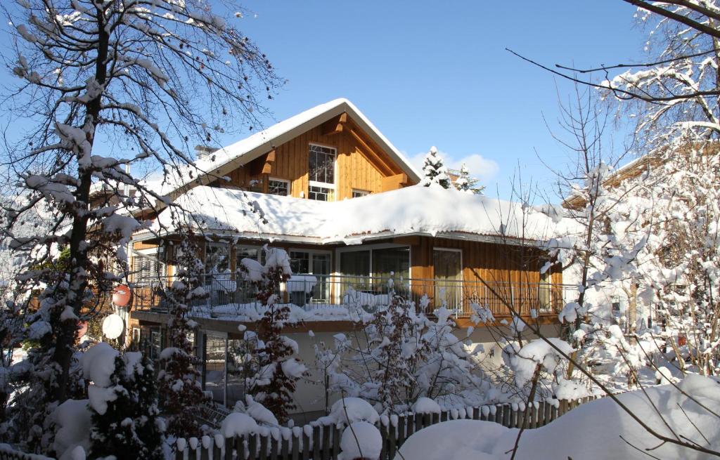 een huis bedekt met sneeuw met een hek bij Alpen-suite in Riezlern