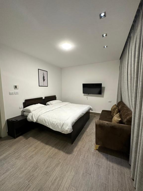 a bedroom with a large bed and a couch at central apartment for rent 23 in Umm Uthainah