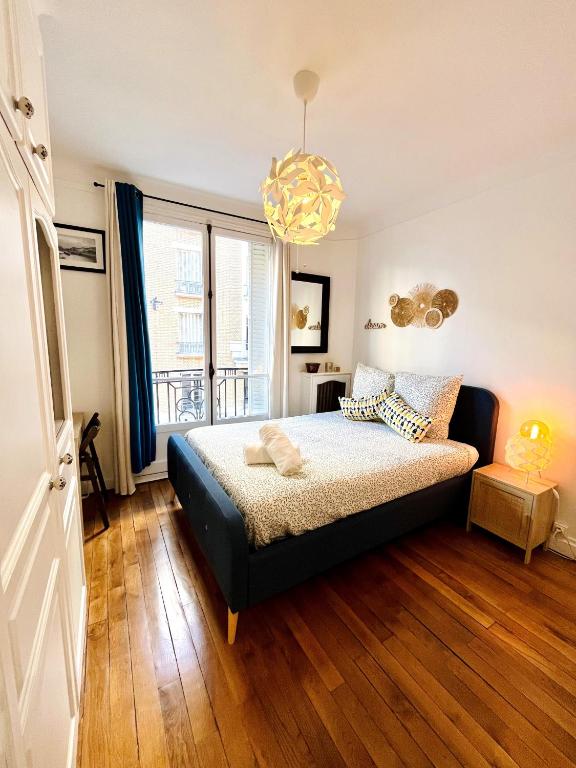 une chambre avec un lit et une grande fenêtre dans l'établissement Magnifique studio cosy Paris 18, à Paris
