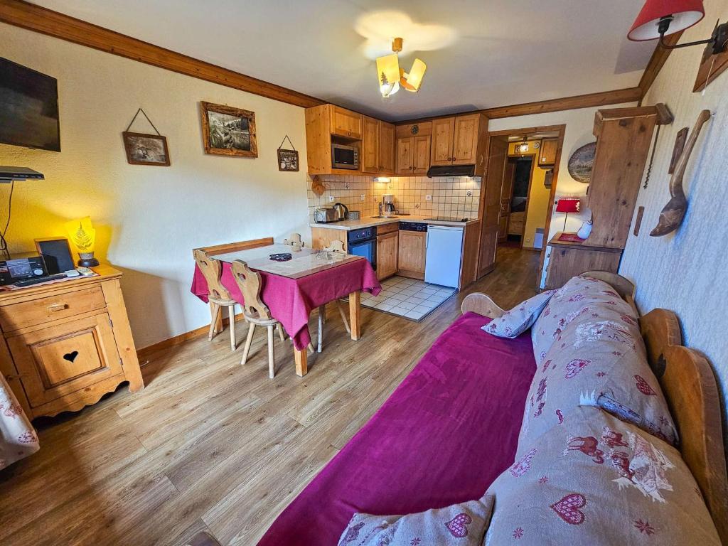 a living room with a couch and a kitchen at Appartement cosy pour 4, cuisine équipée, proche des pistes - FR-1-452-245 in Les Menuires