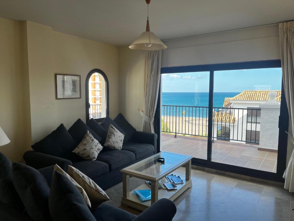 un soggiorno con divano e vista sull'oceano di 3 Bed Beachfront Penthouse 854 with great views a Manilva