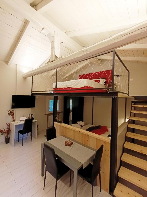 a room with a bunk bed and a table and chairs at CARLOTTA FIERA SUITE in Bologna