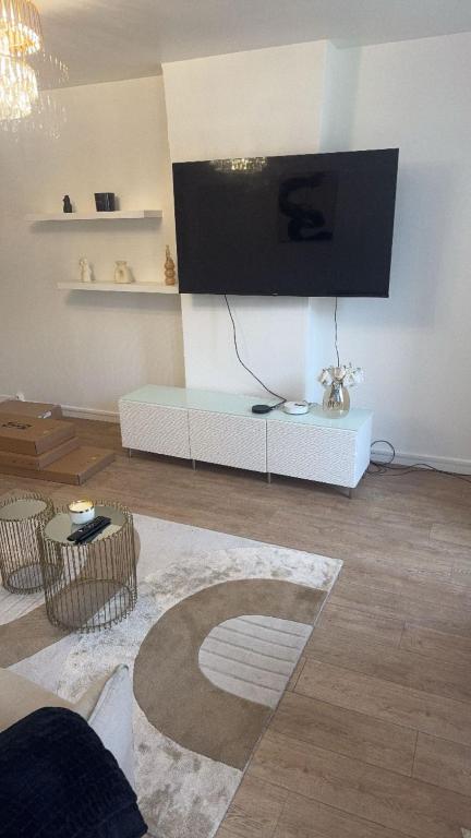 un salon avec une télévision à écran plat au mur dans l'établissement Joys, à Lille