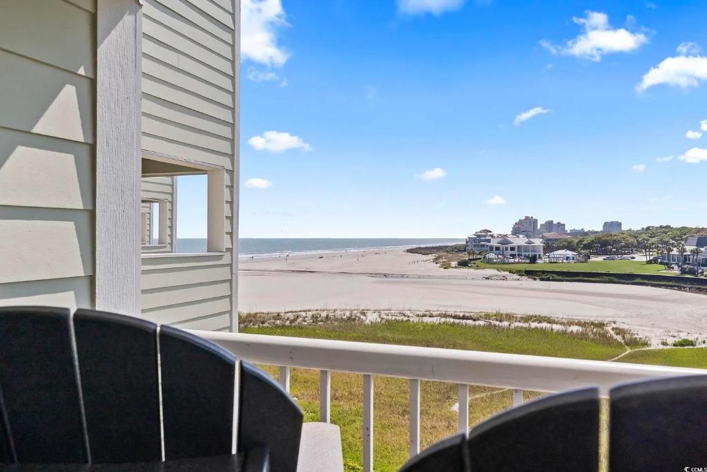 einen Balkon mit Stühlen und Strandblick in der Unterkunft ONE More Sandy Day - 2BR 2BA Beach Condo, Sleeps 6 in Myrtle Beach
