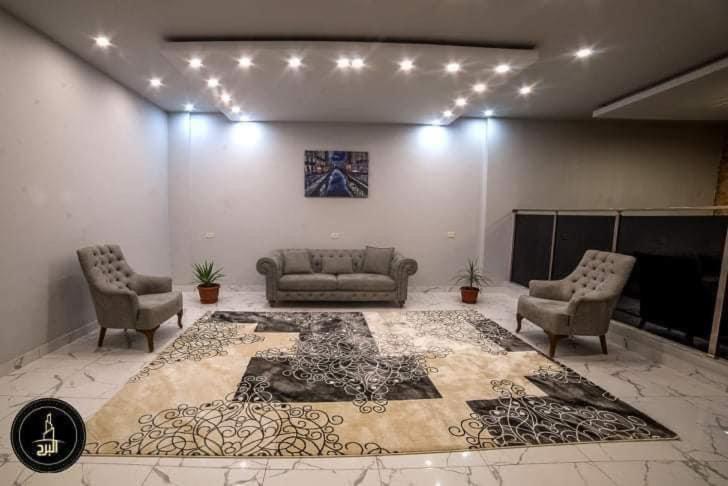 a living room with two couches and a rug at Al Borj Hotel فندق البرج 
