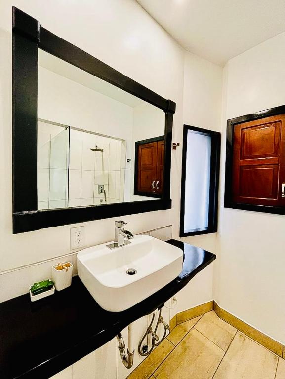 bagno con lavandino e grande specchio di Hotelito del Mar - Main Street a Bocas del Toro