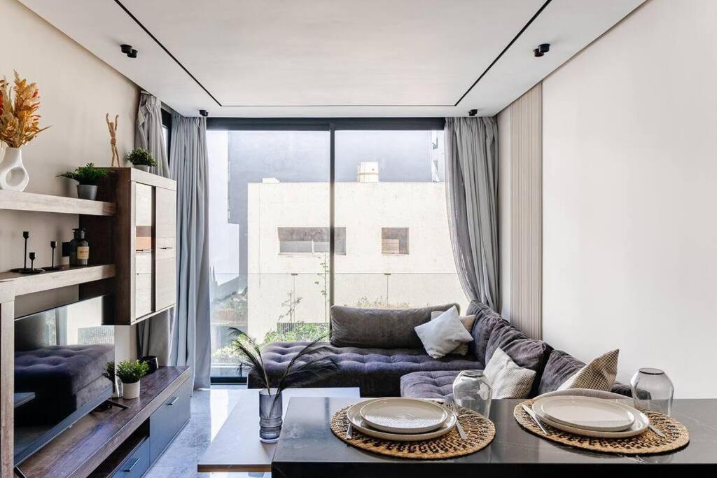 a living room with a blue couch and a large window at Luxury 105 Studio in Casablanca