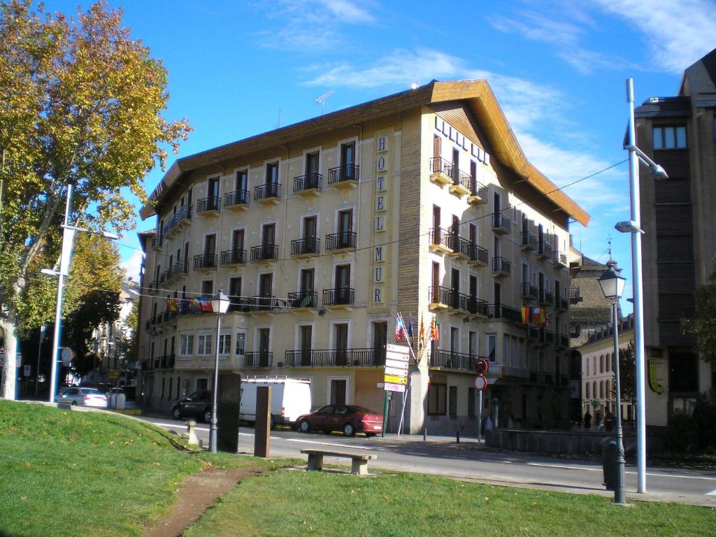 a building on a street with a bench in front of it at Hotel Mur in Jaca