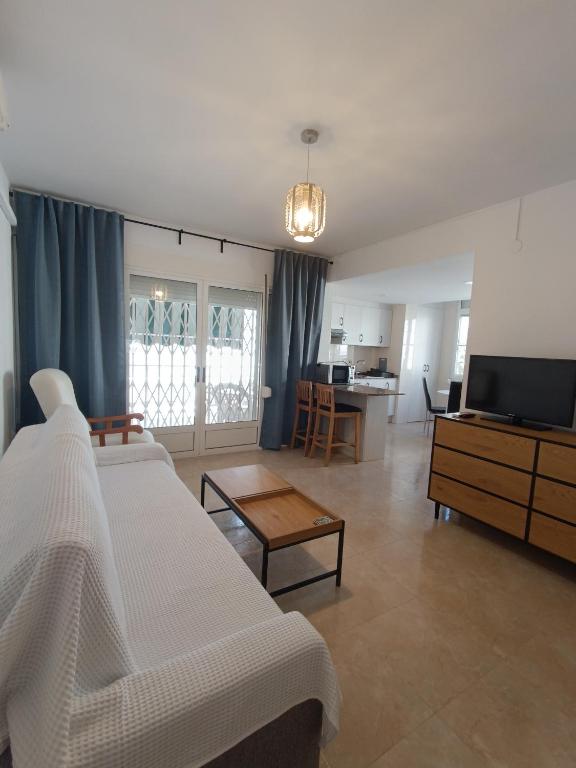 ein Wohnzimmer mit einem Bett, einem TV und einem Tisch in der Unterkunft Blue Day Solo Familias in Puerto de Gandía