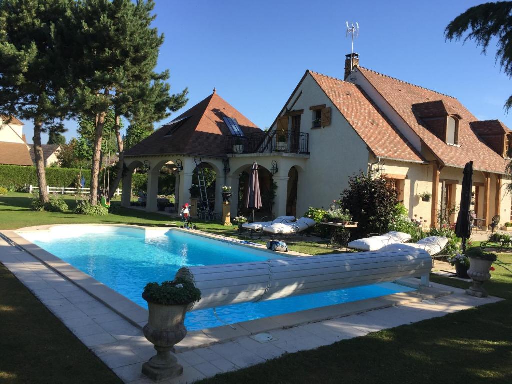 una piscina di fronte a una casa di Les Prémices De La Forêt a Chailly-en-Bière