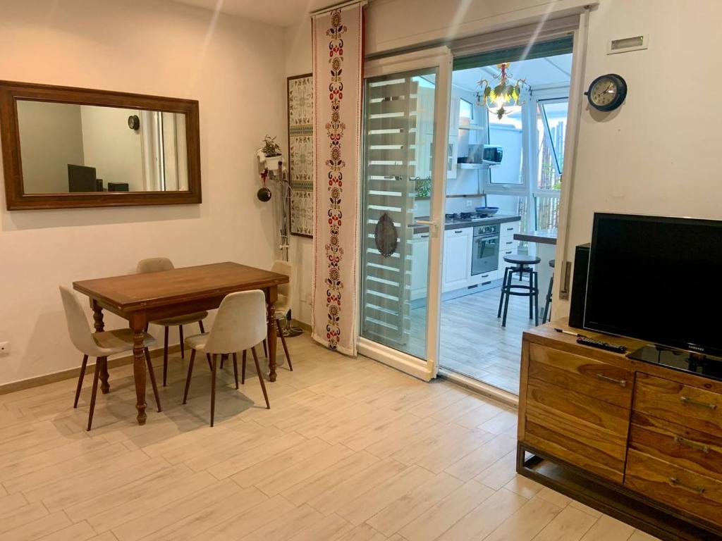 a living room with a wooden table and a television at Alerì Central Apartment - Zona Pedonale in Viareggio